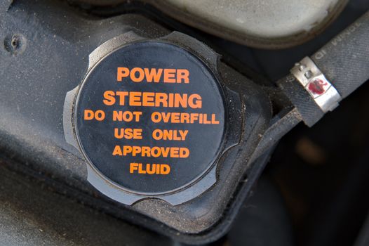 Cap of a power steering oil tank. Do not overfill and use approved fluid only.