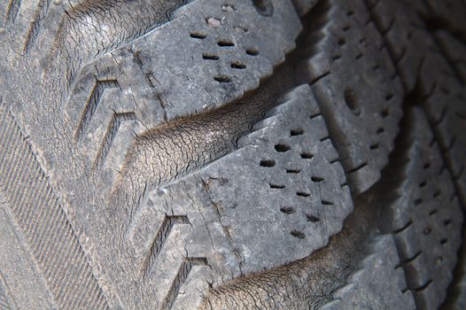 An old tire of a car full of micro cracks.