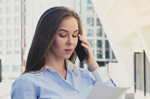 Portrait of a businesswoman talking on the phone near the business center