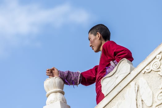 A nun in Lharong Monastery and the Monk houseson surrounded in Sertar, Tibet.  Lharong Monastery is a Tibetan Buddhist Institute at an elevation of about 4300 meters.