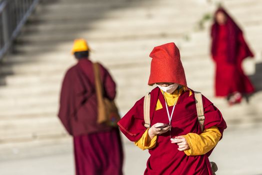 A nun in Lharong Monastery and the Monk houseson surrounded in Sertar, Tibet.  Lharong Monastery is a Tibetan Buddhist Institute at an elevation of about 4300 meters.