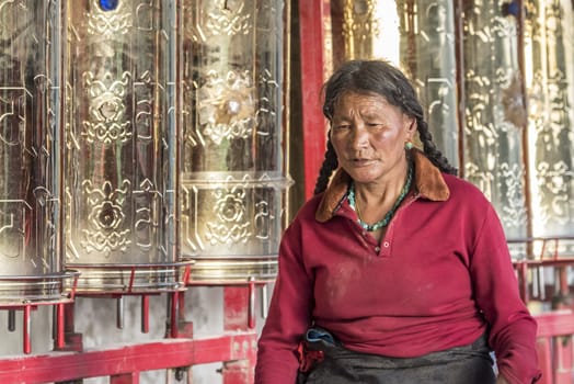 A old buddhist in Lharong Monastery and the Monk houseson surrounded in Sertar, Tibet.  Lharong Monastery is a Tibetan Buddhist Institute at an elevation of about 4300 meters.