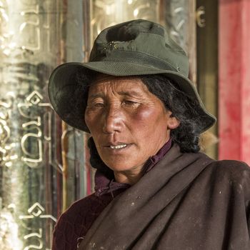 A old buddhist in Lharong Monastery and the Monk houseson surrounded in Sertar, Tibet.  Lharong Monastery is a Tibetan Buddhist Institute at an elevation of about 4300 meters.