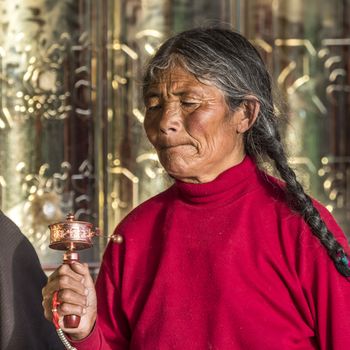 A old buddhist in Lharong Monastery and the Monk houseson surrounded in Sertar, Tibet.  Lharong Monastery is a Tibetan Buddhist Institute at an elevation of about 4300 meters.