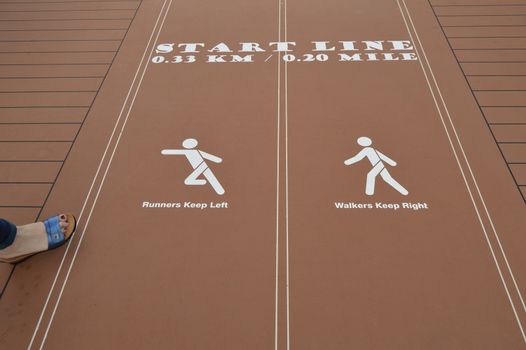 Red treadmill on a cruise ship with the inscription Runners Keep Left, Walkers Keep Right.