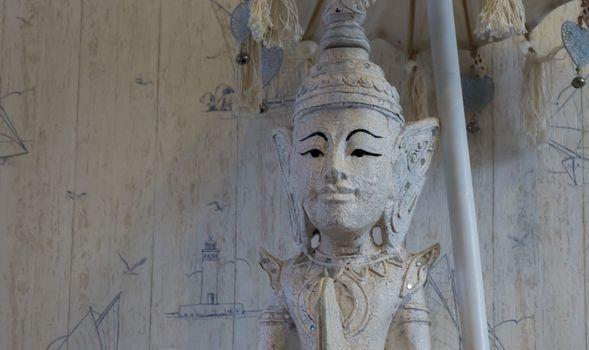 white buddha statue under a umbrella in closeup, a spiritual or buddhist background