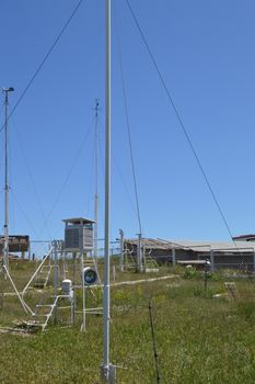 Weather station at the top of the mountain against the blue sky and grass on a Sunny summer day, vertical shot.