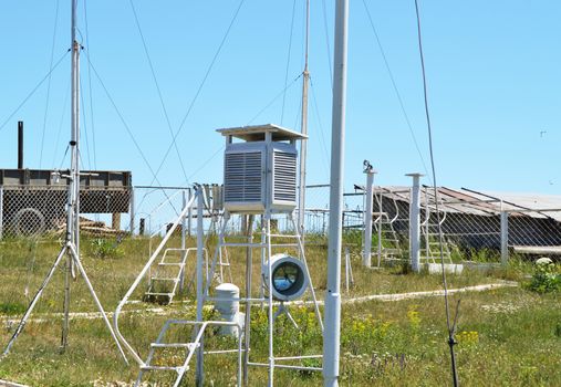 Weather station at the top of the mountain against the blue sky and grass on a Sunny summer day.