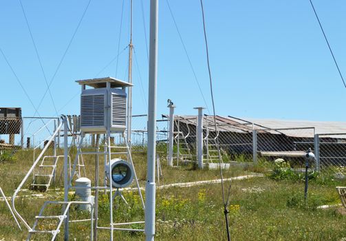 Weather station at the top of the mountain against the blue sky and grass on a Sunny summer day.