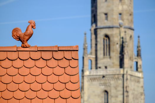 View to cock on roof and tower Daniel of St. Georg church in Noerdlingen in Germany