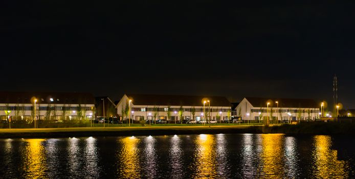 view from the water on houses and driving road at night time, dutch street view of landschapsbaan, the Meern, Utrecht the Netherlands