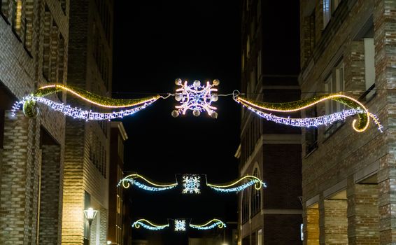 beautiful christmas decorations hanging between the buildings in the city streets at night