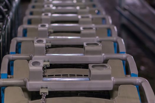 row of plastic supermarket shopping carts in macro closeup, commercial supermarket background