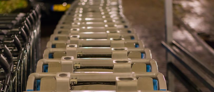 long row of supermarket shopping carts in closeup, a commercial supermarket background