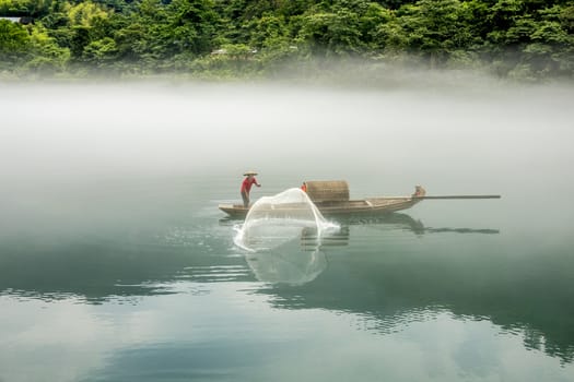 A fisherman in the famous Misty Small Dongjiang (east river) in Chenzhou, Hunan province of China.