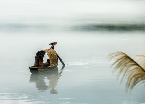 A fisherman in the famous Misty Small Dongjiang (east river) in Chenzhou, Hunan province of China.