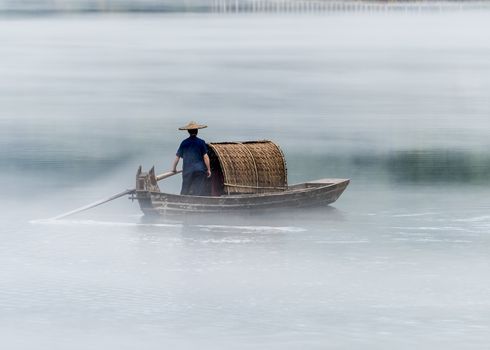 A fisherman in the famous Misty Small Dongjiang (east river) in Chenzhou, Hunan province of China.