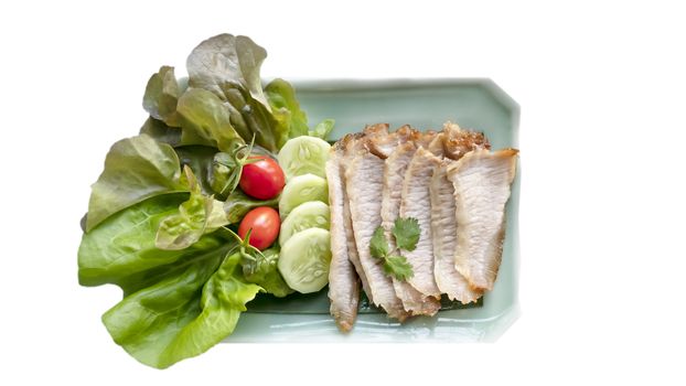 slice of grilled pork served with fresh vegetable