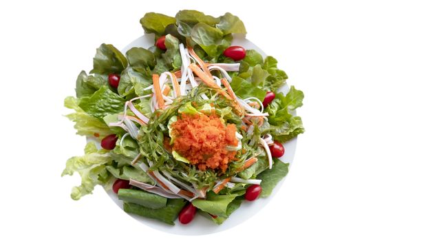 fresh organic salad with fish roe and crab stick on white plate