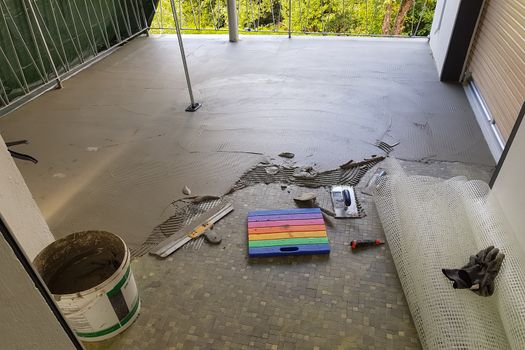 Balcony floor tiles installation. Laying tiles from porcelain. Interior remodeling theme.