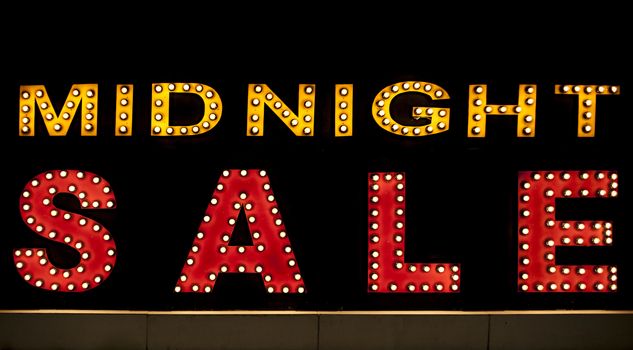 Midnight sale background. Brightly colored vintage advertising sign board with illumination, lamps