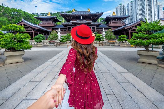 Women tourists holding man's hand and leading him to Chi Lin Nunnery temple, Hong Kong.