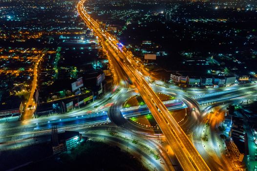 Aerial view of traffic in roundabout and highway at night.