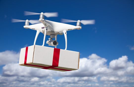 Unmanned Aircraft System (UAV) Quadcopter Drone Delivering Box With Red Ribbon