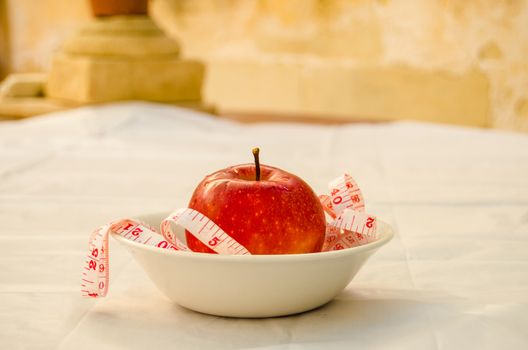 red apple with measurig tape, weigh loss concept, white background