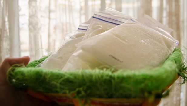 frozen breast milk in storage bags in the basket,breastfeeding concept