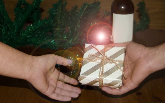 man gifing a gift to a woman hands only, christmas or new year concept