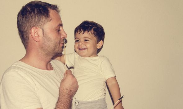 Father and son playng with moustache funny face expressions, family time