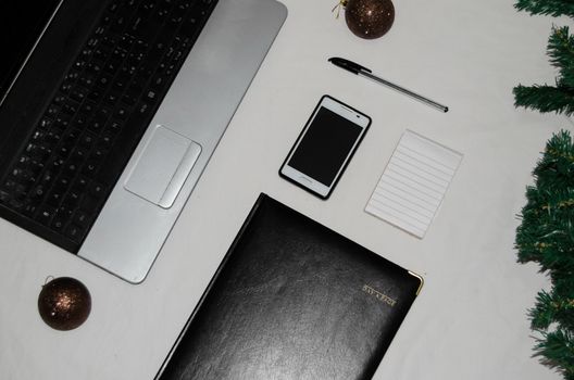 White office desk table with blank notebook, laptop and other office supplies. Top view with copy space, flat lay.