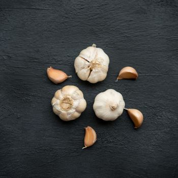 Top view garlic cloves and bulb on dark background.