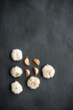 Top view garlic cloves and bulb with copy space on dark background.