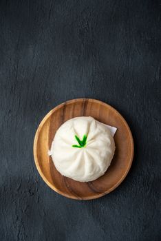 Flat lay Baozi or bao dim sum on plate with copy space on dark background.