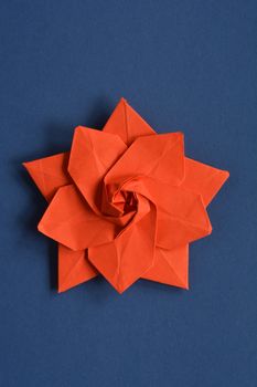 Red origami paper star on dark blue background