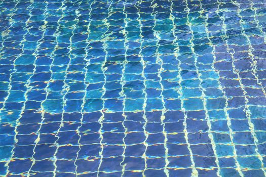 Blue tiles swimming pool water reflection, abstract texture image background.