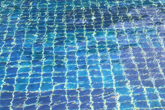 Blue tiles swimming pool water reflection, abstract texture image background.