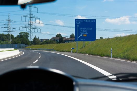 German motorway sign with inscription in German Driving direction to the cities - Velbert, Heiligenhaus, Wuelfrath and Hetterscheidt