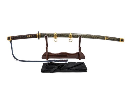 'Kai Gunto' : Japanese Marine Sword From World War 2 with scabbard wrapped by ray skin on wooden stand and  bag in front of, isolated in white background.