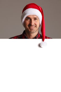 Happy man in Santa hat holding blank banner with copy space
