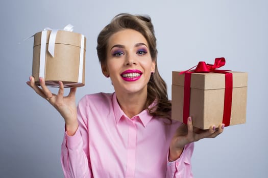 Young woman holding holiday presents with bows