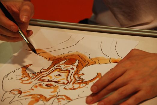 Cartoonist draws with watercolor paintbrush