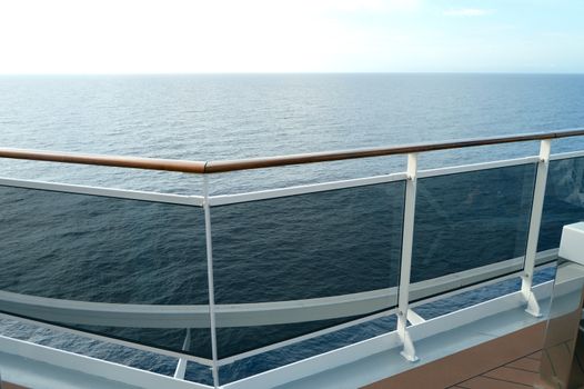 Sea view from the open deck of a modern cruise ship, railing and strong glass wall