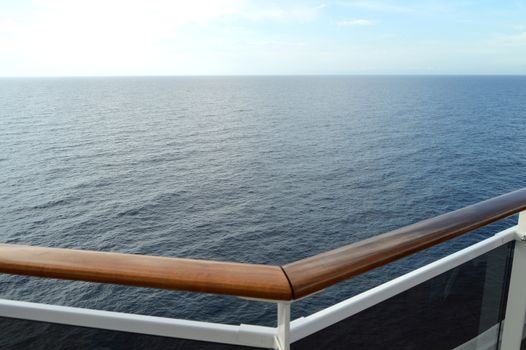 Sea view from the open deck of a modern cruise ship, railing and strong glass wall