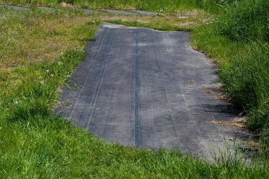 Installation of elastic EPDM synthetic rubber covering on existing asphalt surface as a playground. EPDM safety mats reduce the risk of injury from falls on playgrounds and sports facilities.
