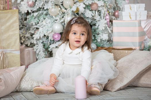 Merry Christmas and Happy Holidays ! Cute funny little child girl near decorated Christmas tree indoors