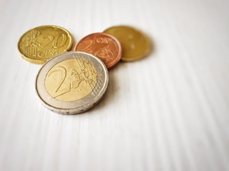 Group of euro coins on a white table. All coins contains the number 2. Money and savings concept