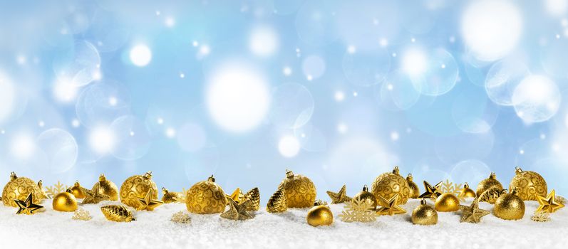 christmas decoration panorama of balls pine cones and stars on snow on bokeh background